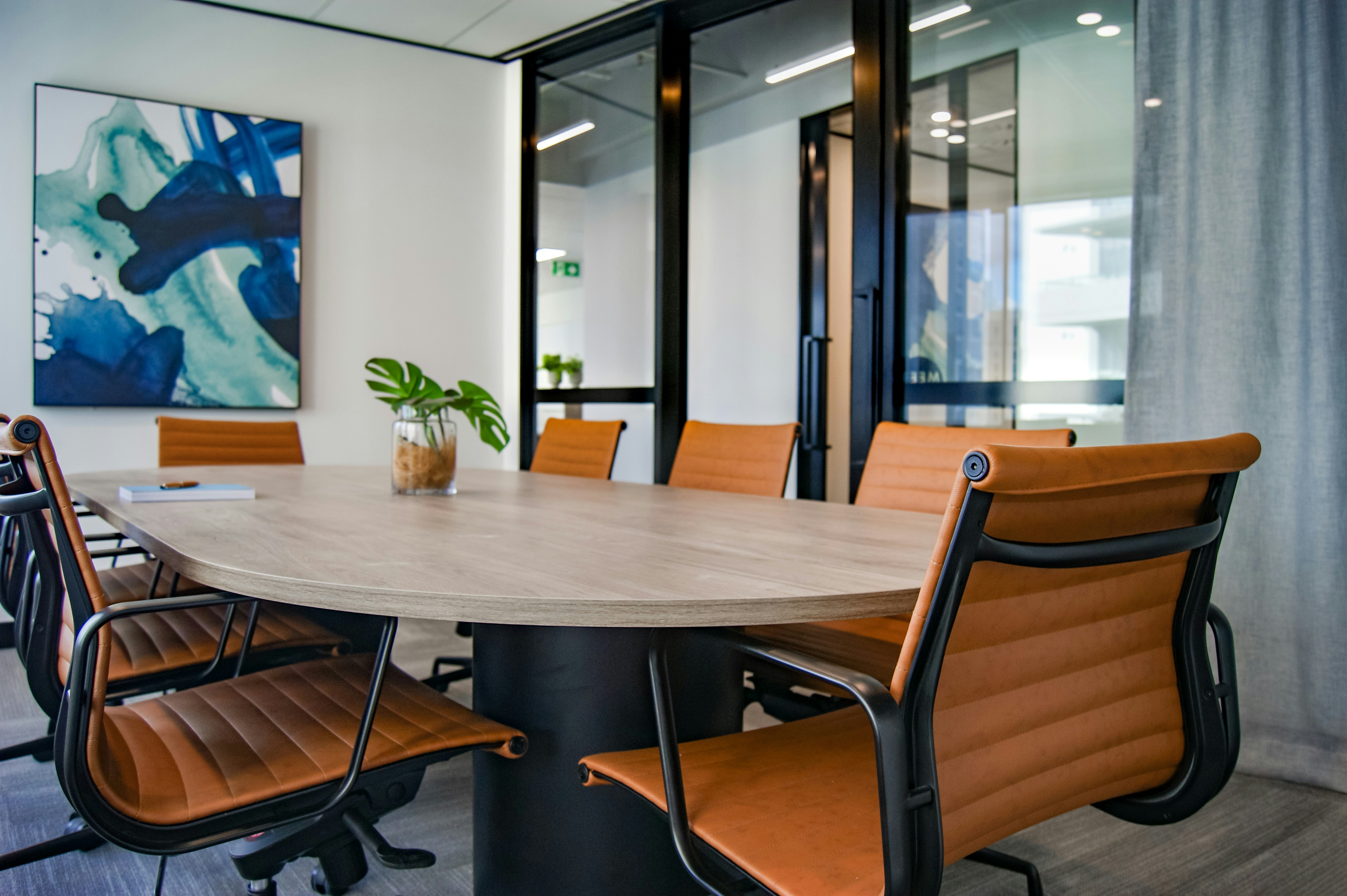Conference room with tan leather office chairs and glass partitions
